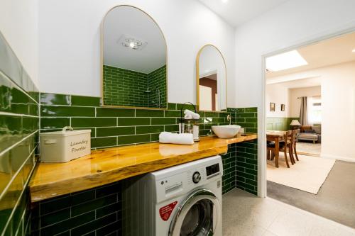 a green tiled bathroom with a washing machine at Convent Franklin - Alice Catherine Unit in Franklin