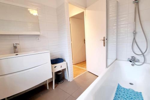 Baño blanco con bañera y lavamanos en Elégant P4 du centre historique en Nimes