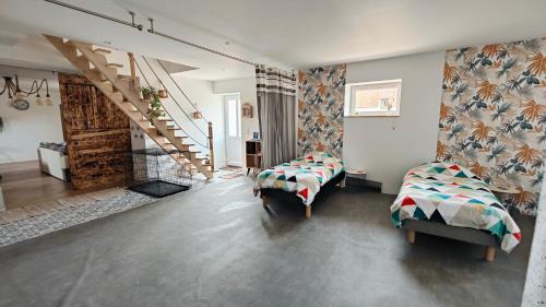 a living room with two beds and a staircase at Entre terres et mer chez Carméla in Bazinghen