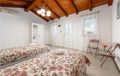 a bedroom with two beds and a chair at 4 Bedroom Stunning Home In Jurani in Ružići