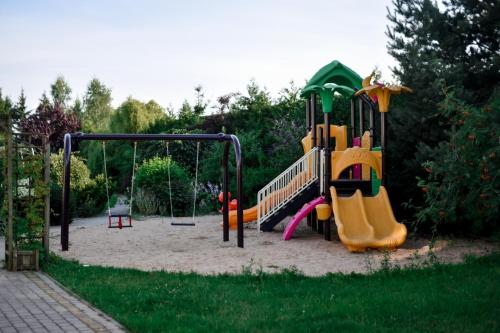 einen Spielplatz mit Rutsche und Spielset in der Unterkunft Jarzębinowy Resort & SPA in Braniewo