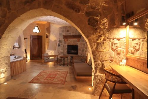 a large room with a stone wall with a sink at Kappadoks Cave Hotel in Uchisar
