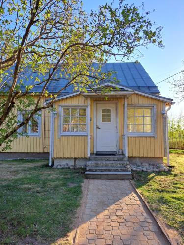 una pequeña casa amarilla con una puerta blanca en Norrby Gård - Sjövik - Alakerta/ 1st floor / 1. våning / Erdgeschoss, en Raseborg