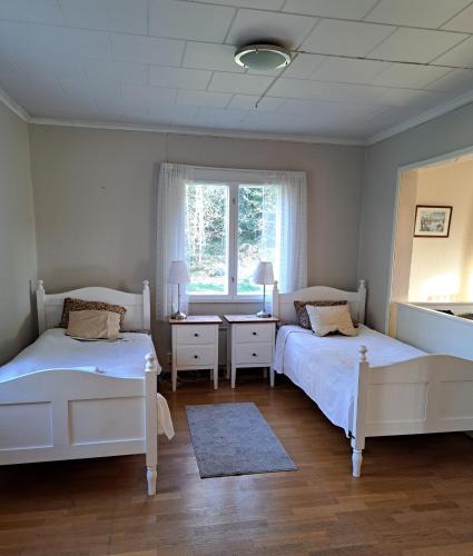 1 dormitorio con 2 camas y ventana en Norrby Gård - Sjövik - Alakerta/ 1st floor / 1. våning / Erdgeschoss, en Raseborg