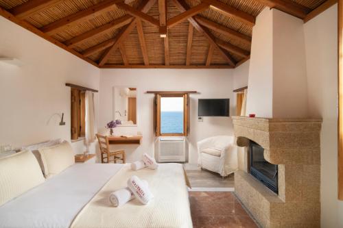 a living room with a bed and a fireplace at Bastione Malvasia Hotel (ex New Malvasia) in Monemvasia