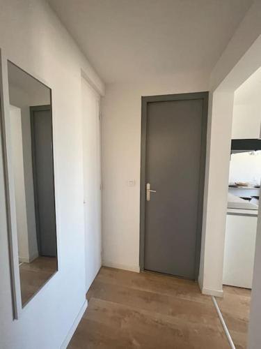an empty room with a door and a mirror at Studio cosy rue Alexander Taylor, Wifi, 2 pers in Pau