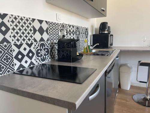 a kitchen with a black counter top in a kitchen at Studio cosy rue Alexander Taylor, Wifi, 2 pers in Pau