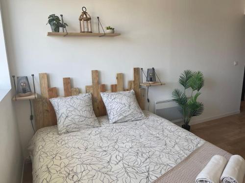 um quarto com uma cama com uma cabeceira de madeira em Studio cosy rue Alexander Taylor, Wifi, 2 pers em Pau