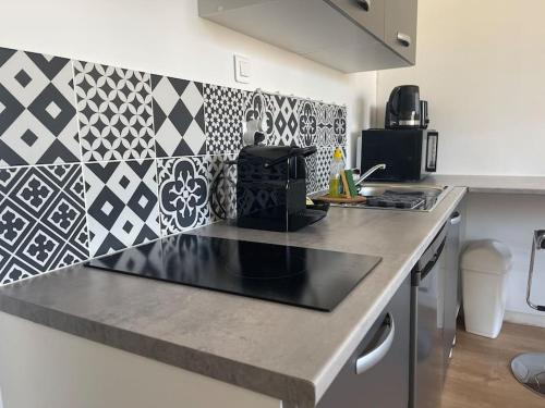 a kitchen with a black counter top in a kitchen at Studio cosy rue Alexander Taylor, Wifi, 2 pers in Pau