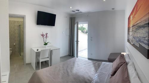 a bedroom with a bed and a desk and a television at Tenuta Verdolivo in Ostuni