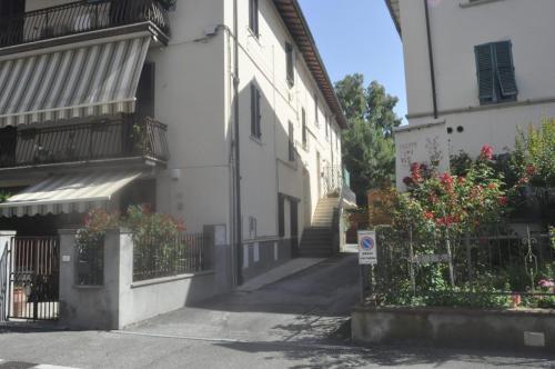 een lege straat met een wit gebouw en bloemen bij Appartamento Ristoro67 in Arezzo