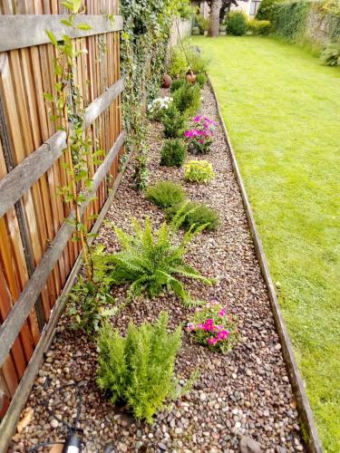 a garden with pink flowers and a fence at Casa Otxandi in Ochandiano