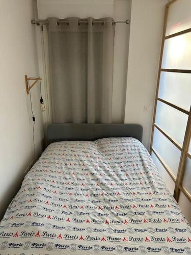 Bett in einem Schlafzimmer mit einer Tagesdecke mit Äpfeln in der Unterkunft L’appartement du bonheur in Colombes