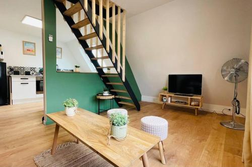 a living room with a table and a staircase at Appartement La Cabane de la Baie. in Étaples