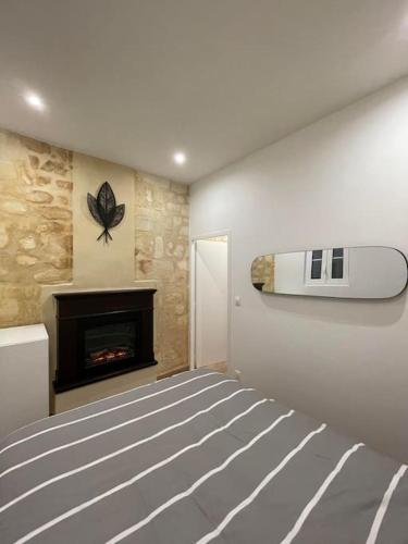 um quarto com uma cama e uma lareira em Appartement cozy à 100m de la gare Saint Jean em Bordeaux