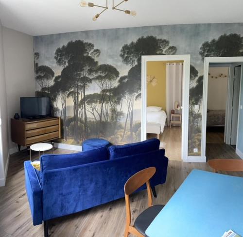 un salon avec un canapé bleu et une chambre dans l'établissement Le tanneur, à Épernay