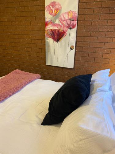 a bed with a pillow sitting on top of it at The Den on Diamond Drive in Wodonga