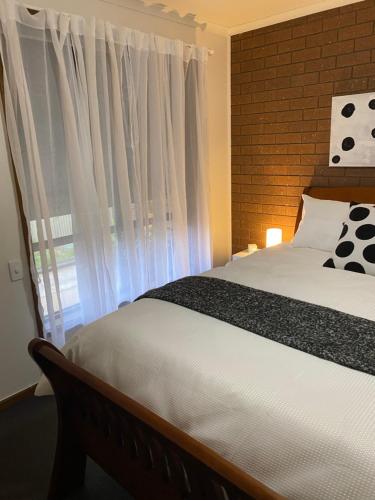 a bedroom with a large bed and a window at The Den on Diamond Drive in Wodonga
