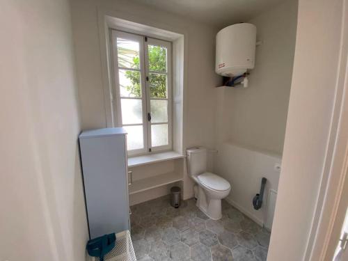 ein Bad mit einem WC und einem Fenster in der Unterkunft Studio du Puits sainte Claire in Courçon