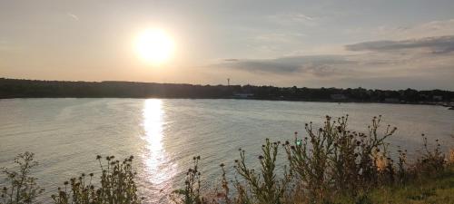 a large lake with the sun reflecting on the water at Family Hotel Mimosa in Tsarevo