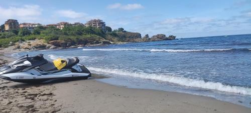 a motorcycle parked on the beach next to the water at Family Hotel Mimosa in Tsarevo