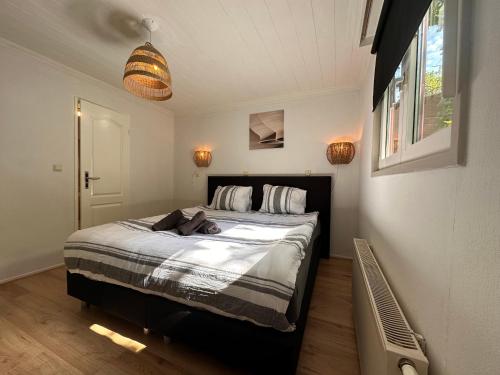 een slaapkamer met een groot bed in een kamer bij BEEKBERGEN staying in the WOODS freestanding chalet WASMACHINE ALL COUNTRY TV CHANNELS EXPATS WELCOME in Beekbergen