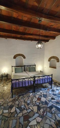 een bed in een kamer met een stenen vloer bij Petrino Vessa in Véssa