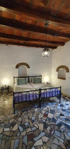 Cama en habitación con suelo de piedra en Petrino Vessa, en Véssa