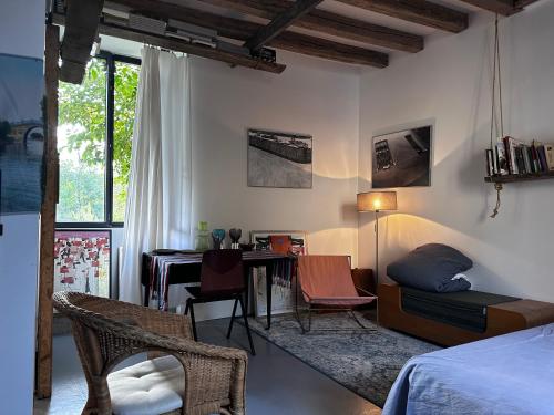Schlafzimmer mit einem Bett, einem Schreibtisch und einem Tisch in der Unterkunft Maison au bord de l’eau in Annay-sur-Serein