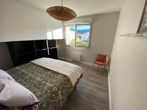 克莱蒙费朗Appart T2 avec parking, loggia, vue Puy de Dôme的一间带床、窗户和椅子的卧室