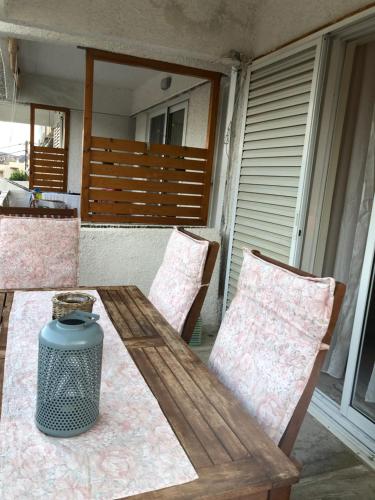 a wooden table and two chairs on a porch at Studio στο Τολό in Tolo