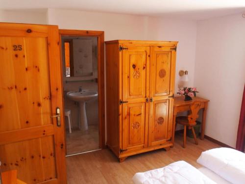 a bathroom with a wooden cabinet and a sink at Hotel Col Serena in Etroubles