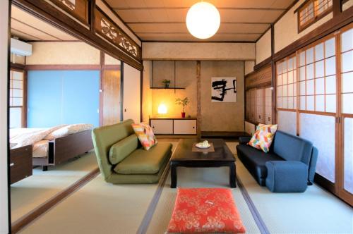 een kamer met 2 stoelen en een tafel en een bed bij Oto Iro Riva HOUSE - Vacation STAY 18694v in Kure