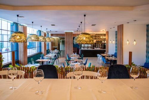 un comedor con una mesa con copas de vino en Hotel Las Terrazas & Suite, en Albolote
