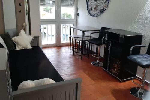 sala de estar con sofá, mesa y sillas en Studio cabine à barcares, en Le Barcarès