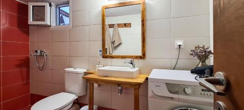 a bathroom with a toilet and a sink and a mirror at House on Sea Sifnos in Cherronisos