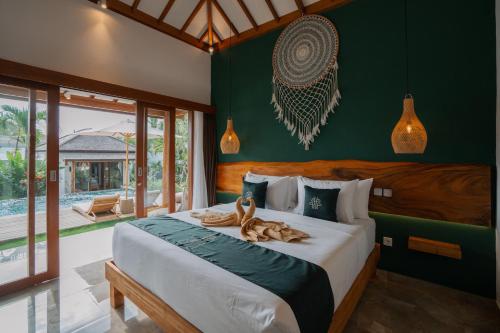 a bedroom with a bed with two animals on it at EHOA BALI Nyanyi Boutique Hotel in Tanah Lot