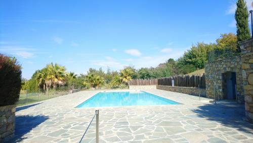 - une piscine dans une cour dotée d'un mur en pierre dans l'établissement Appartement premium T3 résidence piscine, à La Croix-Valmer