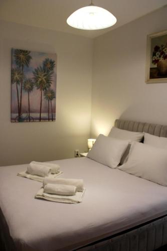 a bedroom with a bed with towels on it at Bjelopera Rooms in Zaton