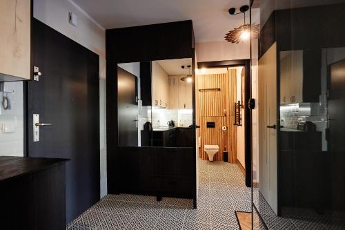 a bathroom with a black door and a sink at Apartament Incognito Rynek in Tarnobrzeg