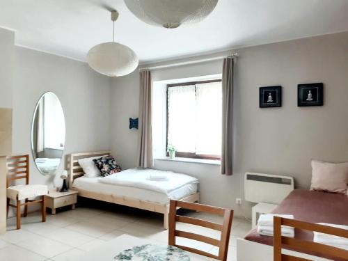 a small bedroom with a bed and a window at Apartamenty Rodzinne Pilica PARK in Sulejów