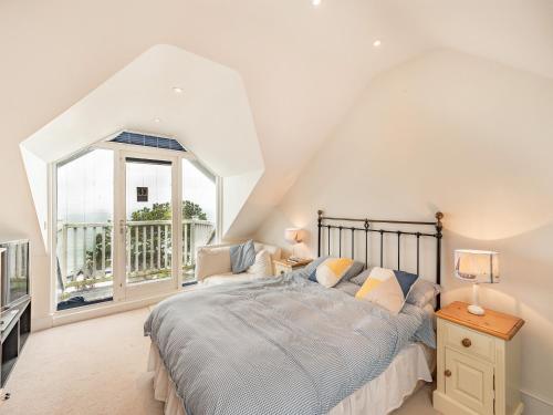 a bedroom with a bed and a large window at The Cottage in St Margarets at Cliff
