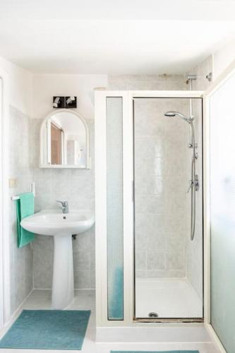 a white bathroom with a sink and a shower at Un passo dal MARE Due dall'ETNA in Giardini Naxos
