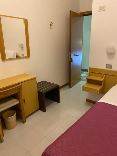 baño con espejo, cama y lavamanos en Hotel Ferrara, en Chianciano Terme