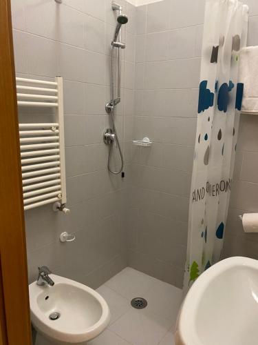 y baño con ducha, aseo y lavamanos. en Hotel Ferrara, en Chianciano Terme