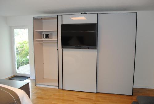 un grande frigorifero bianco con una TV sopra di FeWo-Hochblauen a Badenweiler