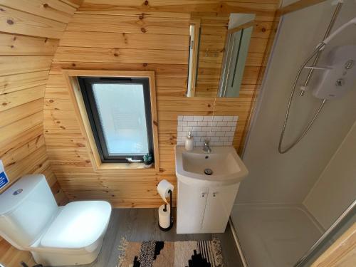 a small bathroom with a toilet and a sink at Timber Valley Pods in Galston