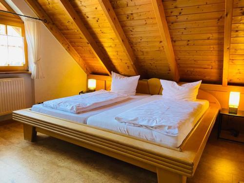 a large bed in a room with a wooden ceiling at Linde Diersburg Stammhaus in Diersburg