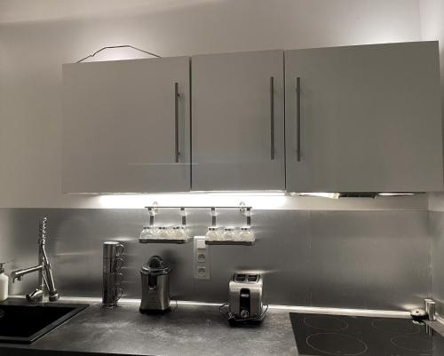 une cuisine avec des armoires blanches et un évier dans l'établissement Spacieux T3 place Comédie gare Saint Roch, à Montpellier