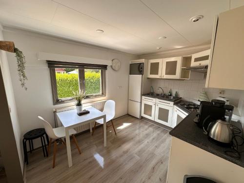 uma pequena cozinha com mesa e cadeiras num quarto em Freestanding Holiday Home BEEKBERGEN - WASMACHINE ALL COUNTRY TV CHANNELS em Beekbergen
